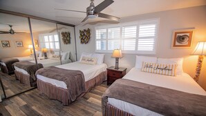 A hotel room with two beds, a ceiling fan, a large mirror, and a window with blinds. - ONE BEDROOM CONDO 809 (San Diego)