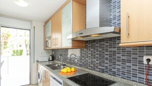 Une cuisine moderne dotée de plans de travail en granit, d’une cuisinière encastrée, d’un évier et d’armoires en bois.