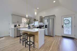 A modern kitchen with a central island, stainless steel appliances, and pendant lighting. - The Carriage House-Serene, Rural Setting w/Firepit (Columbia)