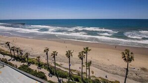 A beach with palm trees and a pier in the background. - TWO BEDROOM CONDO 708 (San Diego)