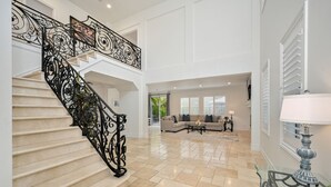 Amplia sala de estar con escalera, sofá modular y una mesa de centro de vidrio.