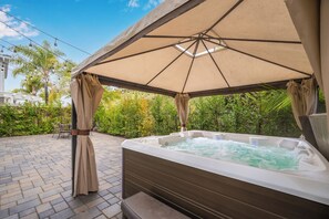 A hot tub under a canopy with a brick patio and greenery in the background. - Large Home in Gated Community near Monarch Beach with Jacuzzi (Dana Point)
