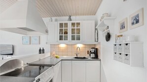 Une cuisine moderne avec des armoires blanches, un évier en acier inoxydable et un lave-vaisselle Bosch.