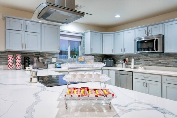 Enjoy cooking and snacking in this well-equipped kitchen with a large window and ample counter space.