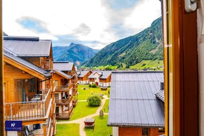 A view of a mountain village with wooden buildings and a clear sky.