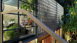 A modern building with a glass facade, a staircase, and lush greenery. - GARDEN HOUSE in Historical Center, with Garage (Porto)