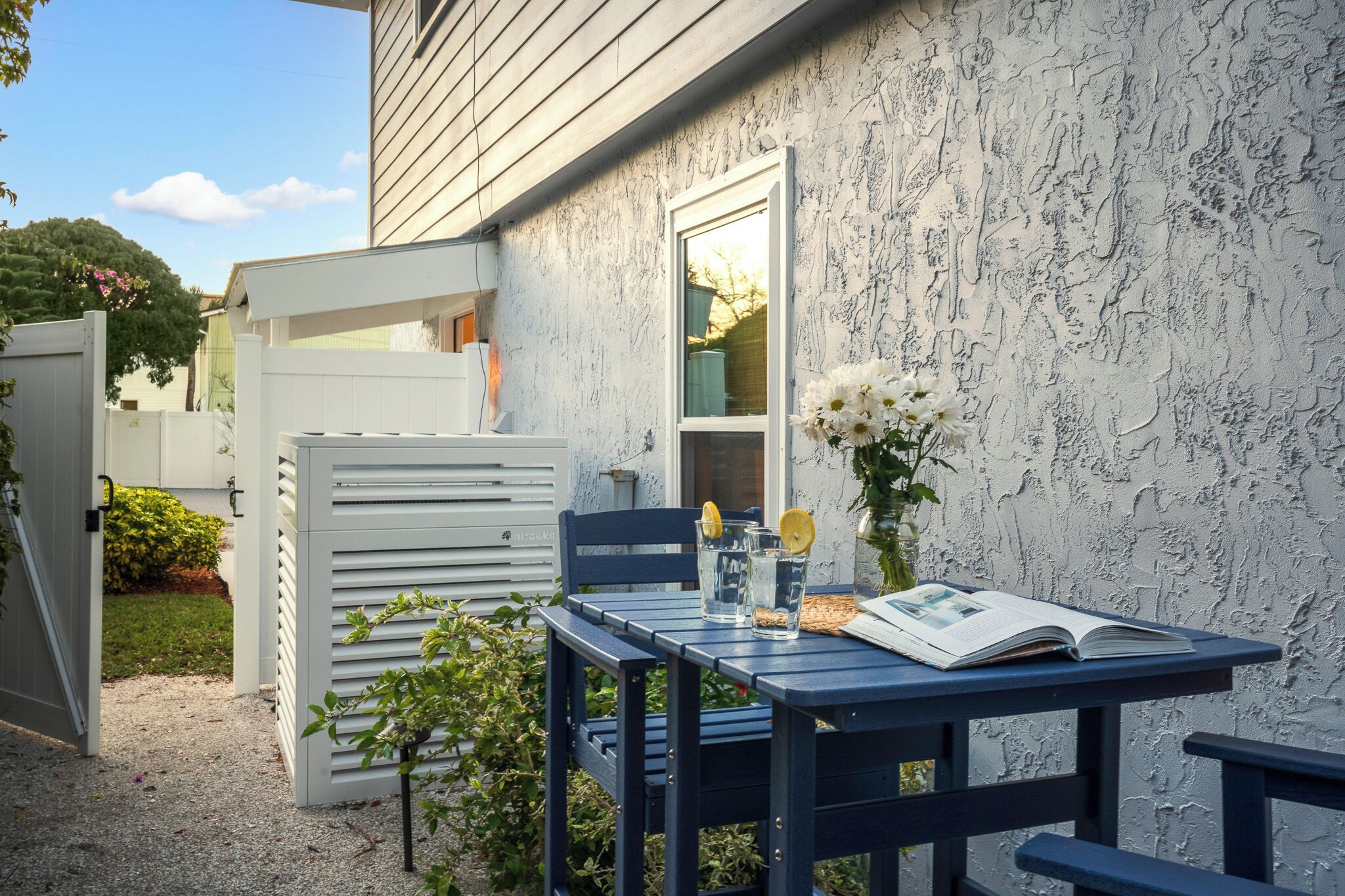 A patio with a table, chairs, and a book.