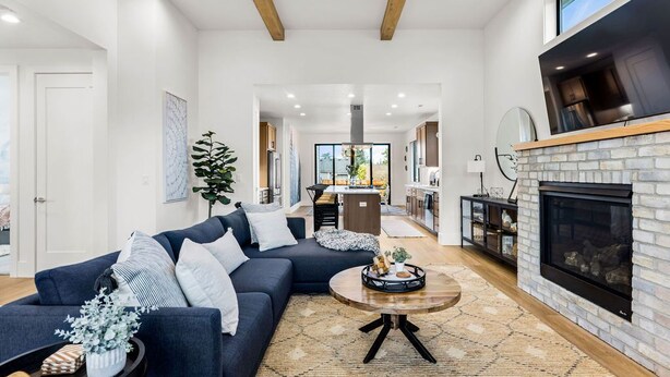 Ein modernes Wohnzimmer mit einem dunkelblauen Sofa, einem runden Couchtisch und einem Kamin.