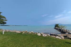 Eine grüne Wiese mit felsiger Küste und freiem Blick auf das Meer.