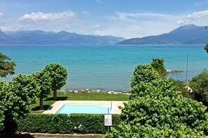 Una piscina con vistas a un lago y montañas al fondo.