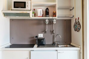 Eine kleine Küche mit einer Mikrowelle, einem Toaster und einem Spülbecken.