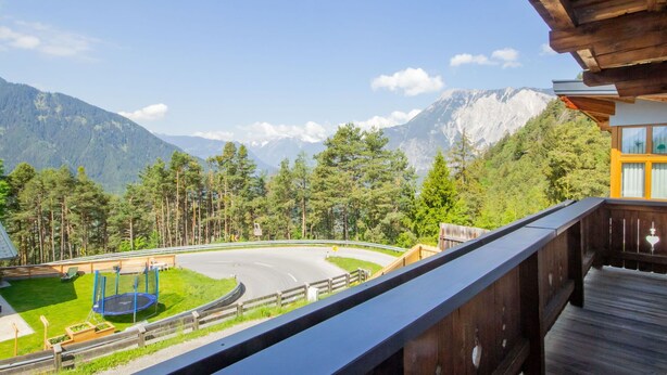 A balcony with a view of a winding road, lush greenery, and mountains in the background. - Beautiful  villa for 5 people with WIFI, TV and terrace (Oetz)