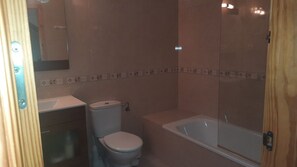 Een bad/douchecombinatie, handdoeken