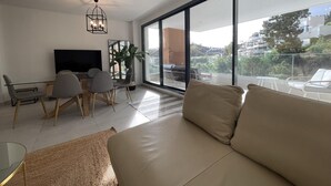 Ett modernt vardagsrum med en soffa, en tv och en matplats.