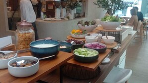 A buffet setup with various food items and utensils.