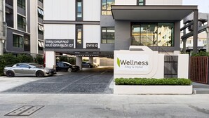 A modern Wellness Stay & Hotel building with a clean, minimalist design, featuring a prominent entrance and a well-maintained exterior.