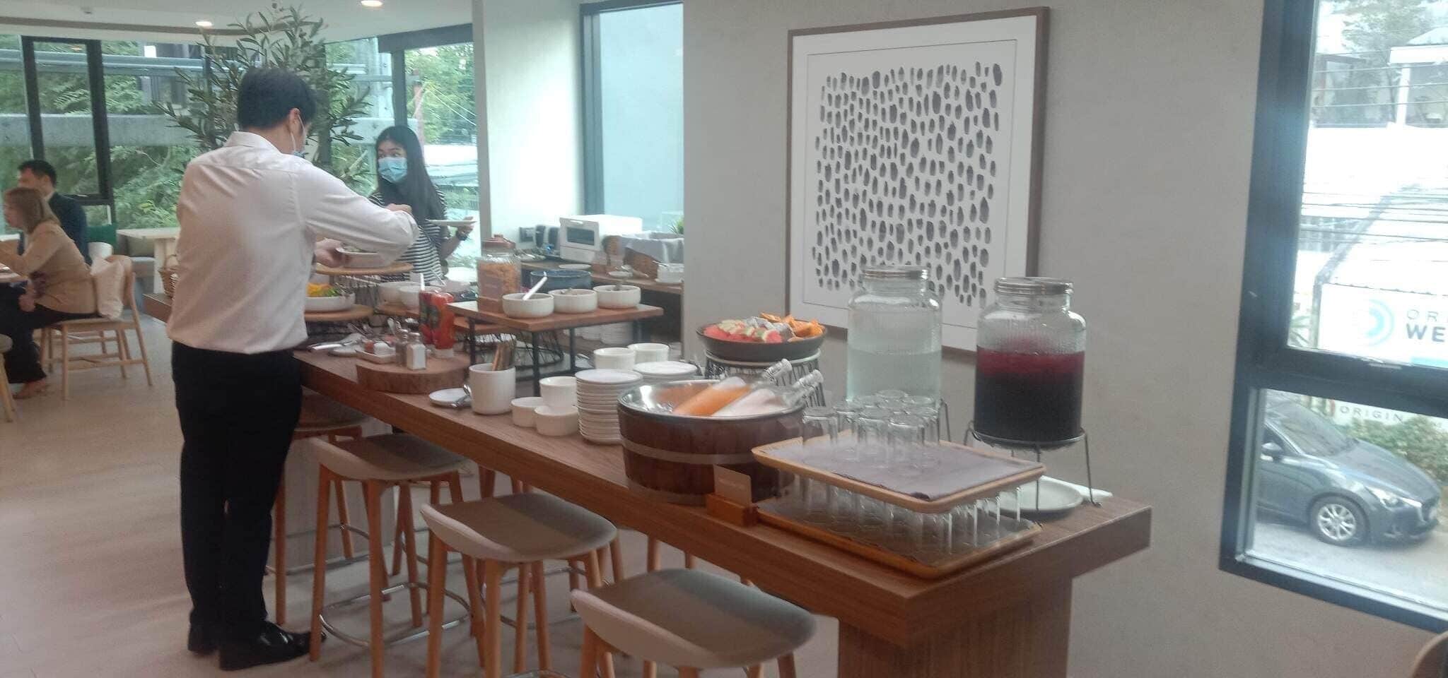 Un café con barra, taburetes y un amplio ventanal.