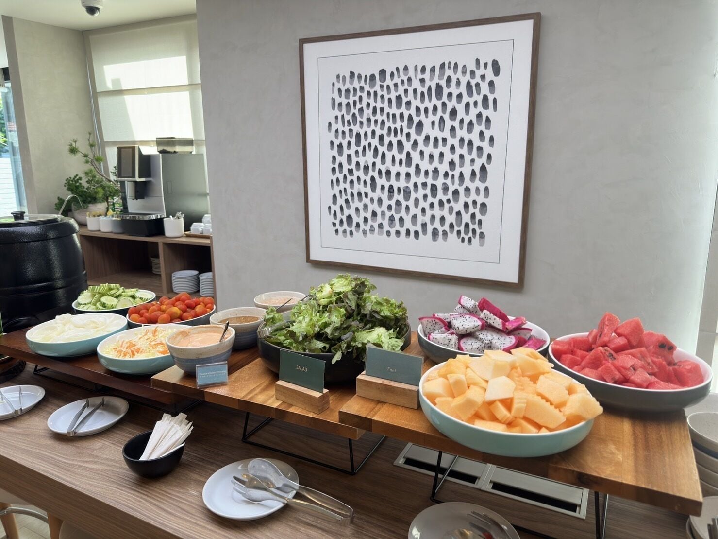 Ein Buffet mit verschiedenen Speisen, darunter Salat, Obst und Gemüse.