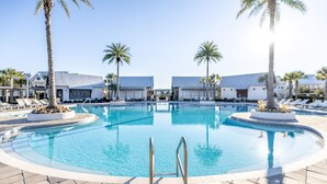 A large, clear swimming pool with a central ladder, surrounded by lounge chairs and palm trees. - Cozy 3bed townhome close to beach/step from Hub (Rosemary Beach)