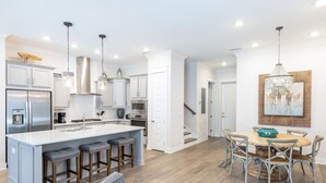 A modern kitchen with a central island, bar stools, and pendant lighting. - Cozy 3bed townhome close to beach/step from Hub (Rosemary Beach)