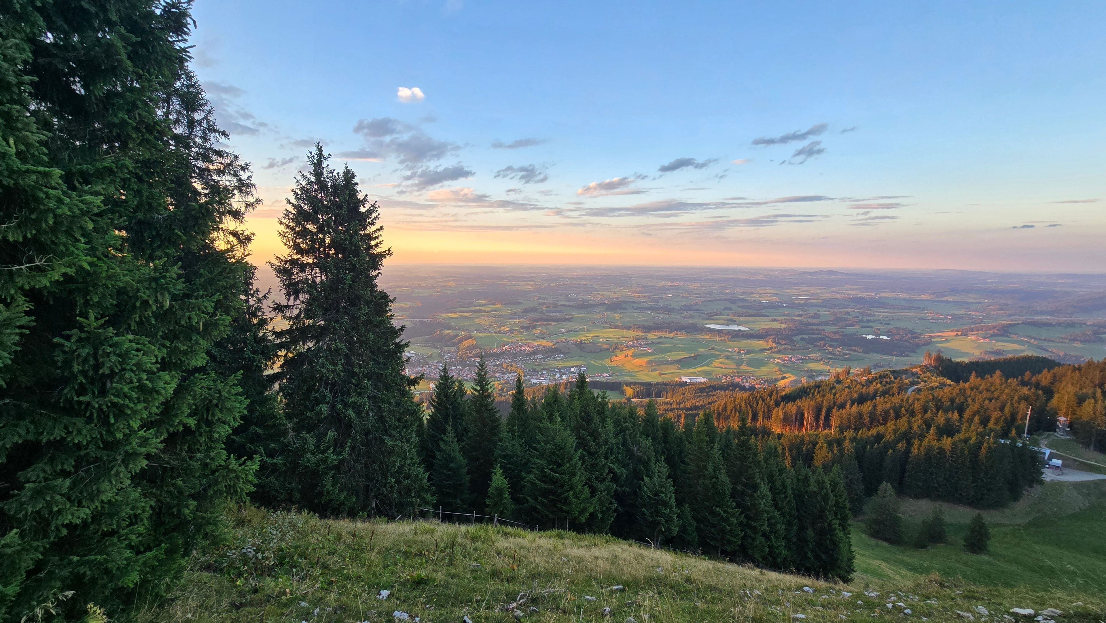 A panoramic view of a landscape with dense forests and a distant town.