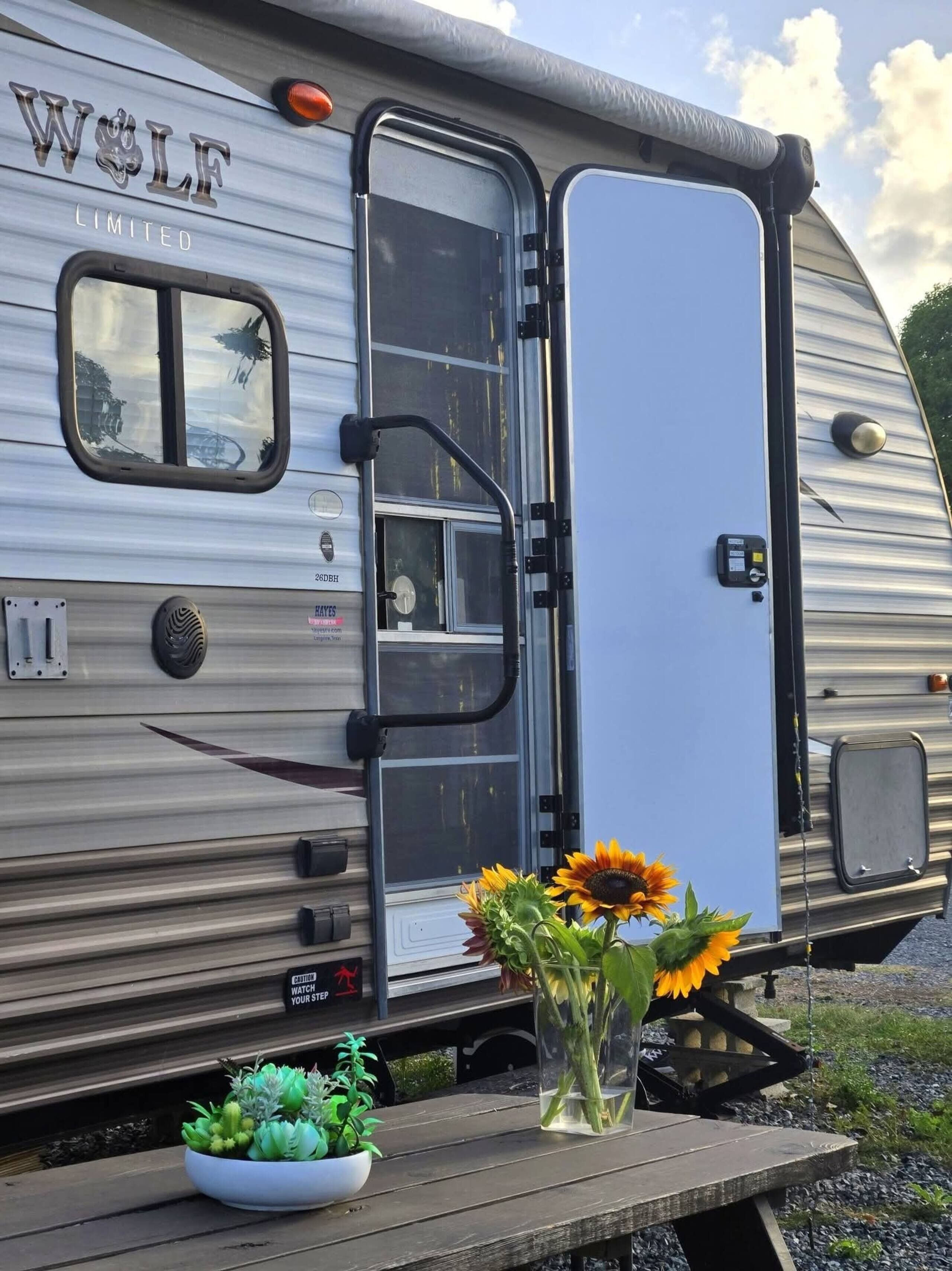 Una autocaravana con puerta corredera, ventana pequeña y aire acondicionado instalado.