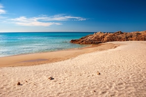 A sandy beach with clear blue water and rocky outcrops. - Baia Delle Palme Bilo 4 Premium, Pula ( IT ), Italy (Pula ( IT ))