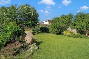 Ein gepflegter Garten mit einem Haus im Hintergrund.