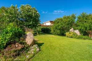 A well-maintained garden with a house in the background.