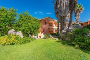 A hotel with a central courtyard, palm trees, and a clear blue sky. - Palau Green Village Bilo, Palau, Italy (Palau)