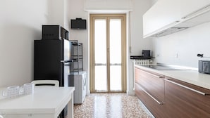 A compact kitchen with a refrigerator, microwave, and a small countertop. - Risorgimento 99 A in Sesto San Giovanni (Sesto San Giovanni)