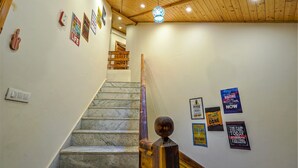 Un escalier avec des marches en marbre, des rampes en bois et un plafond en bois.