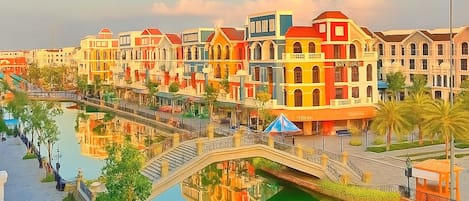 A hotel with colorful buildings, a bridge, and a water canal.