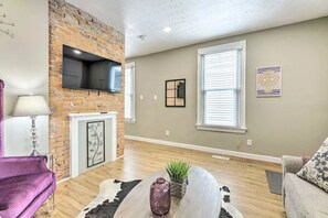 Relax in this inviting living space with a cozy fireplace, plush armchair, and comfortable sofa.