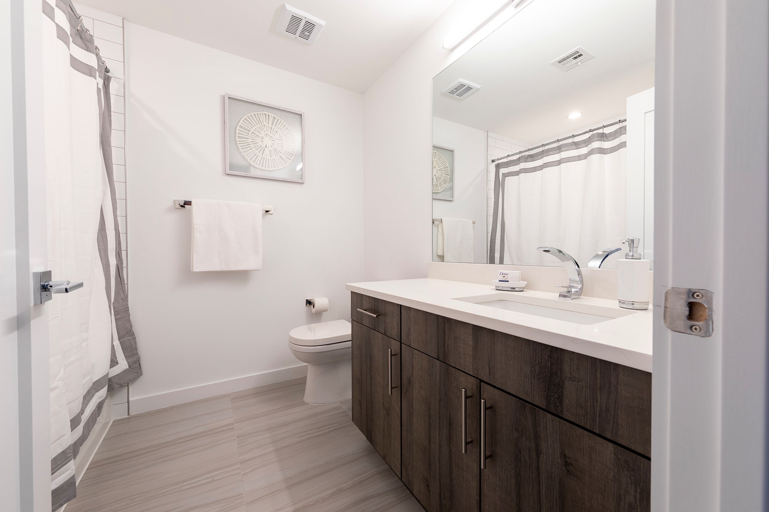 Un baño moderno con inodoro, lavabo y ducha.