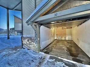 Garage entrance to a residential property with a concrete floor and wooden door frame.