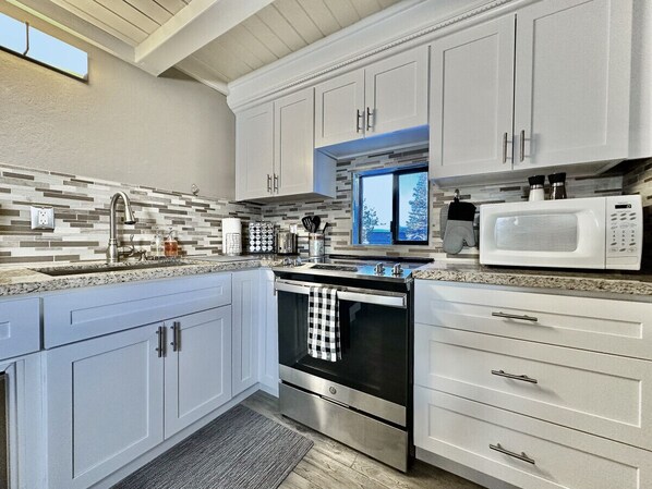 Enjoy cooking in this well-lit kitchen with a stainless steel range and microwave.