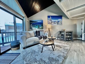Relax in this cozy space with a sofa, coffee table, and side table, offering a view of the surrounding landscape.