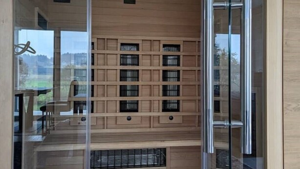 Un intérieur moderne avec une porte vitrée donnant sur une terrasse en bois.