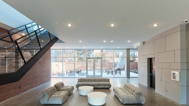 A spacious lobby with a modern staircase, large seating area, and a view of the outdoors. - Modern 3 BR Loft -shared Deck - gym - Mins to NYC (Hoboken)