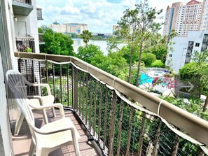 Enjoy a serene view of the pool and lush surroundings from this balcony.