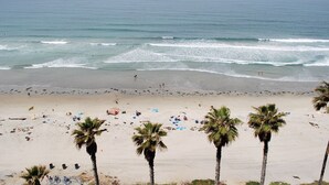 A beach with palm trees, people, and waves. - ONE BEDROOM CONDO 706 (San Diego)