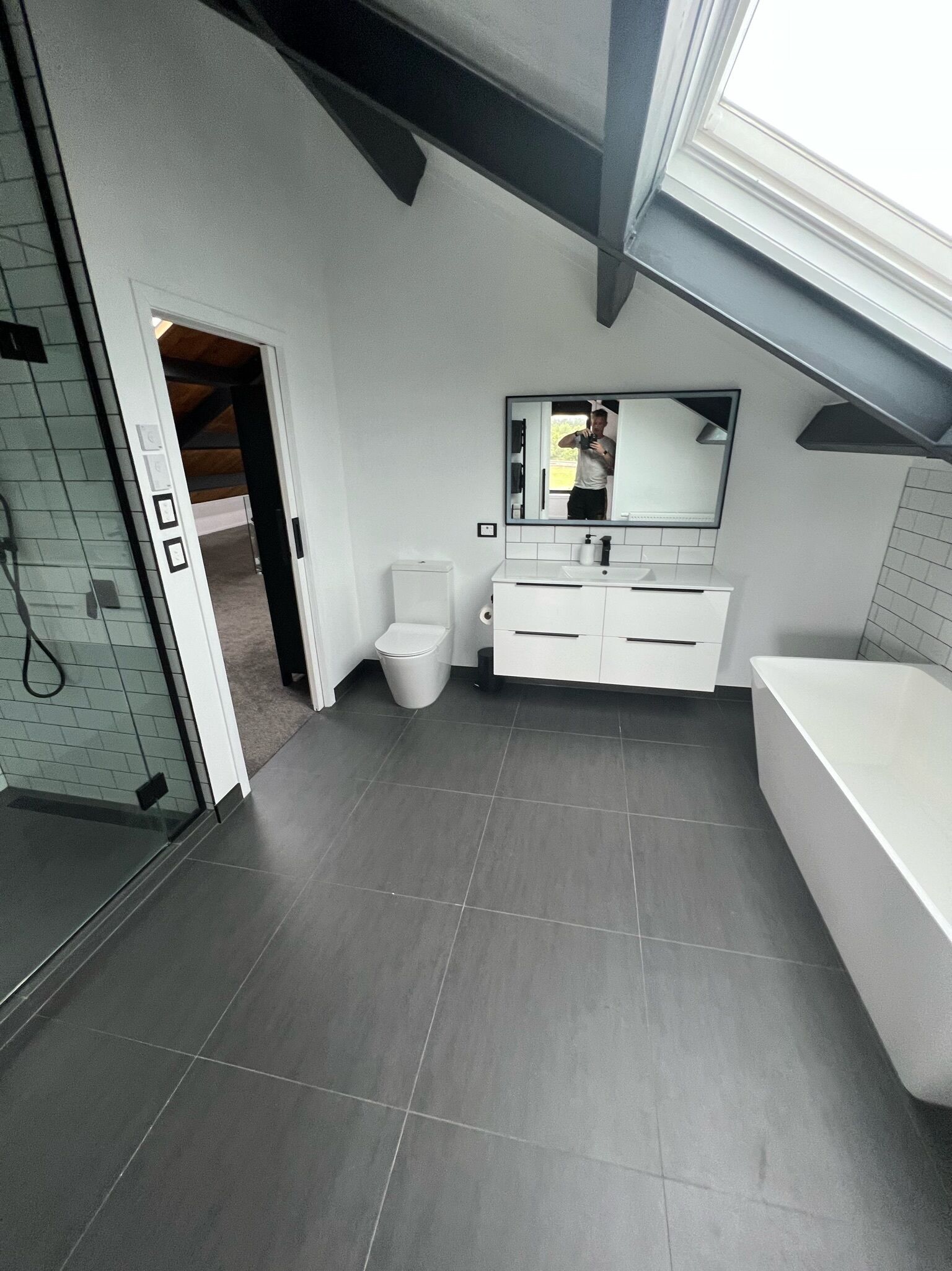 A modern bathroom with a toilet, sink, and bathtub.