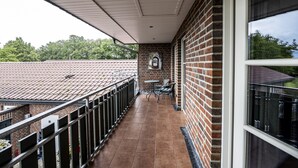 A covered balcony with a tiled floor, a brick wall, and a window. - FerBeautiful apartment close to the Netherlands (Ahaus)