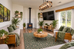Una sala de estar moderna con chimenea, sofás, una mesa de centro y un televisor.