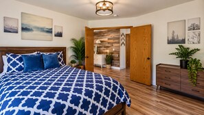 A bedroom with a bed, wooden headboard, and a nightstand. There is a wooden wardrobe and a plant on the side. - Oasis Riverfront House - Gazebo overlooks the River, 5 miles to Sequoia SNP gate (Three Rivers)