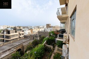 Un quartier résidentiel composé de plusieurs immeubles, dont un avec un balcon agrémenté de plantes en pot.