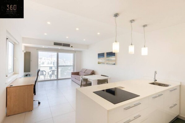 Un appartement moderne doté d’un îlot de cuisine, d’un coin repas et d’un balcon avec vue.