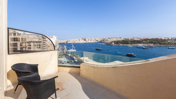 A balcony with a view of a harbor, including boats and a cityscape in the background. - Sliema Ferries APT, with beautiful views AC & WIFI (Sliema)