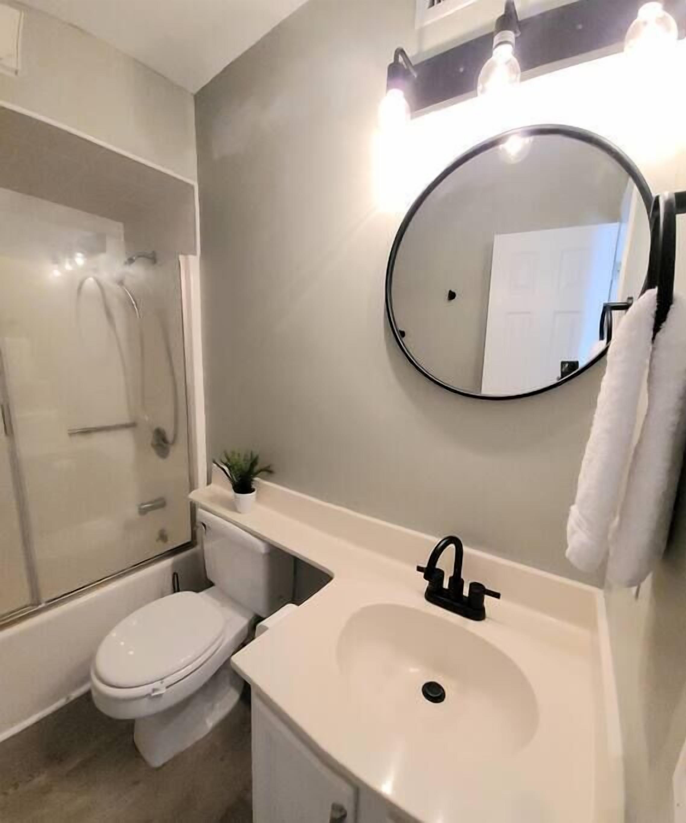 Un bagno moderno con toilette, lavandino e doccia.